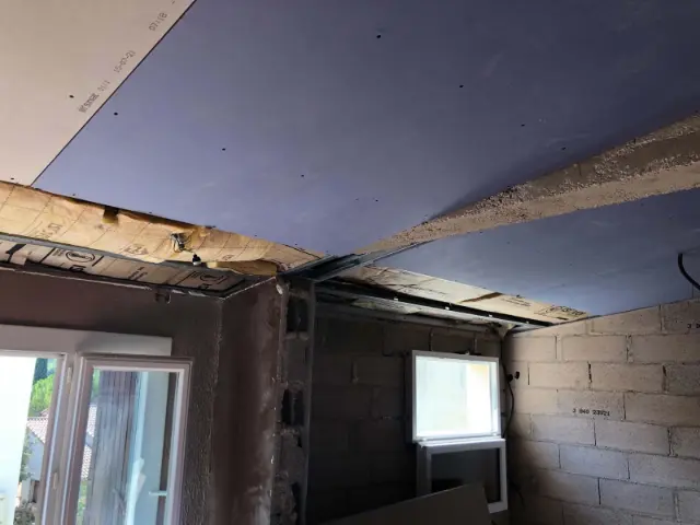 Plafond en plaques de plâtre sur ossature métallique, avec isolant en laine minérale